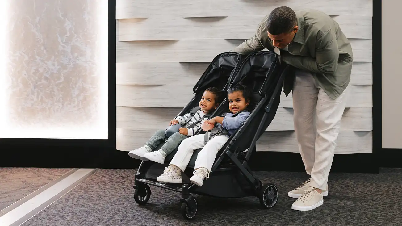 Parent pushing two children in the stroller
